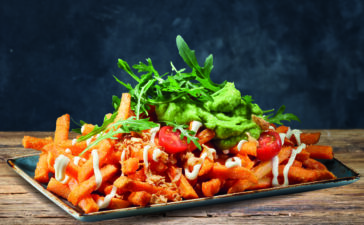 Bei Peter Pane macht eine ordentliche Portion Guacamole aus snackigen Pommes eine sättigende pflanzliche Speise: das Trend-Gericht Loaded Fries. (Bild: Peter Pane)